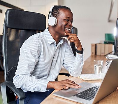 Professional African-American Man smiling and listening to podcast